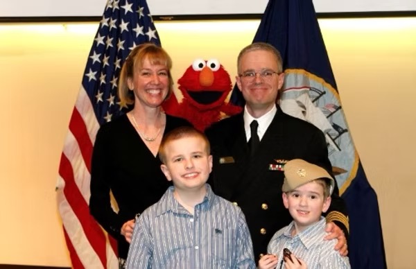 Russell Shilling with family and Elmo at a Navy event celebrating his promotion to Captain.